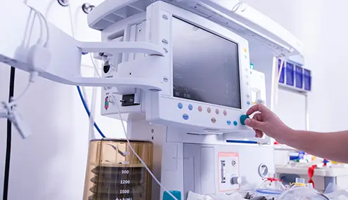 a person is pressing a button on a medical monitor