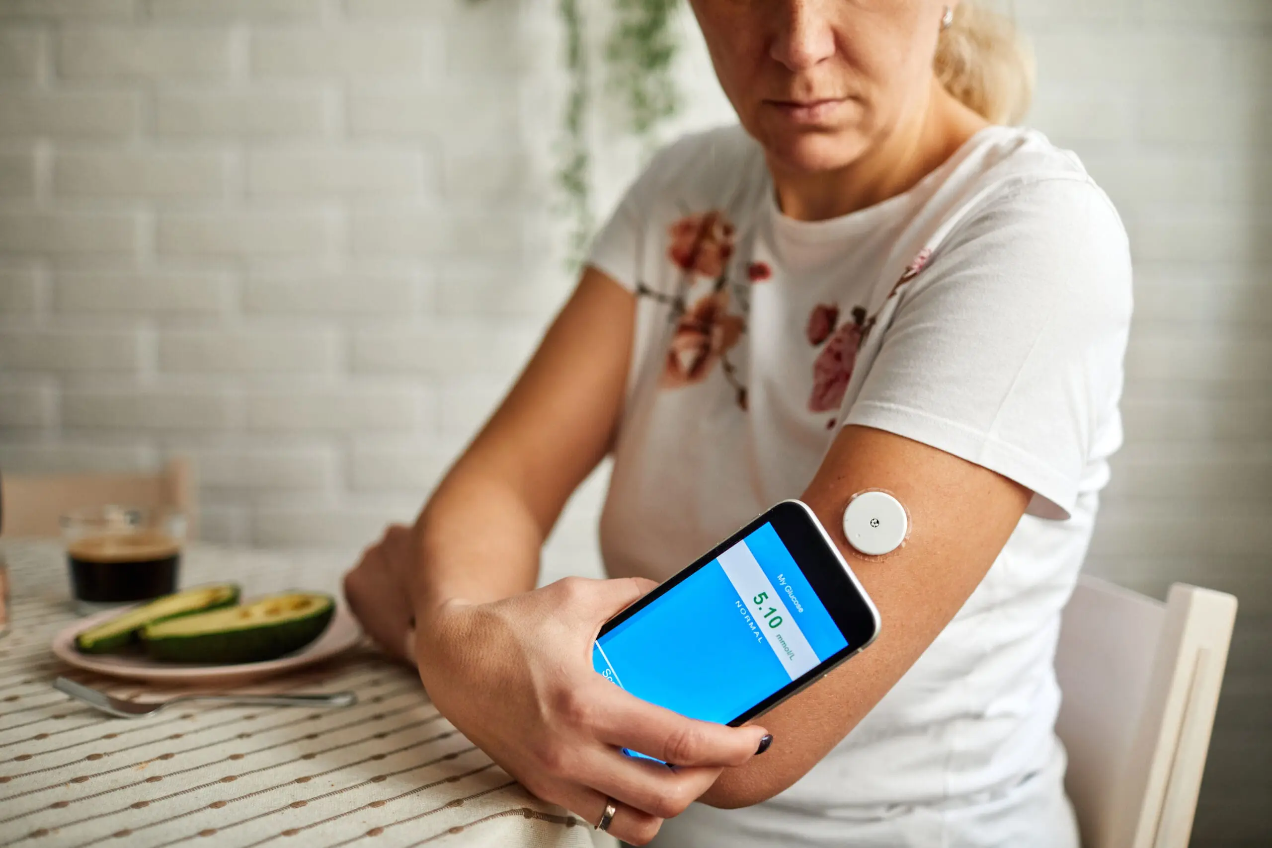 a women taking her glucose levels with a wearable device